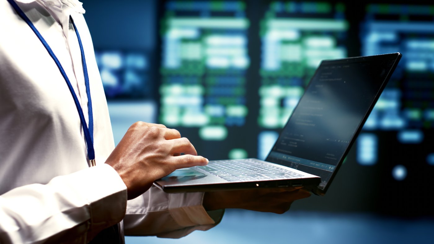 Analyst reviewing live data dashboards on a laptop