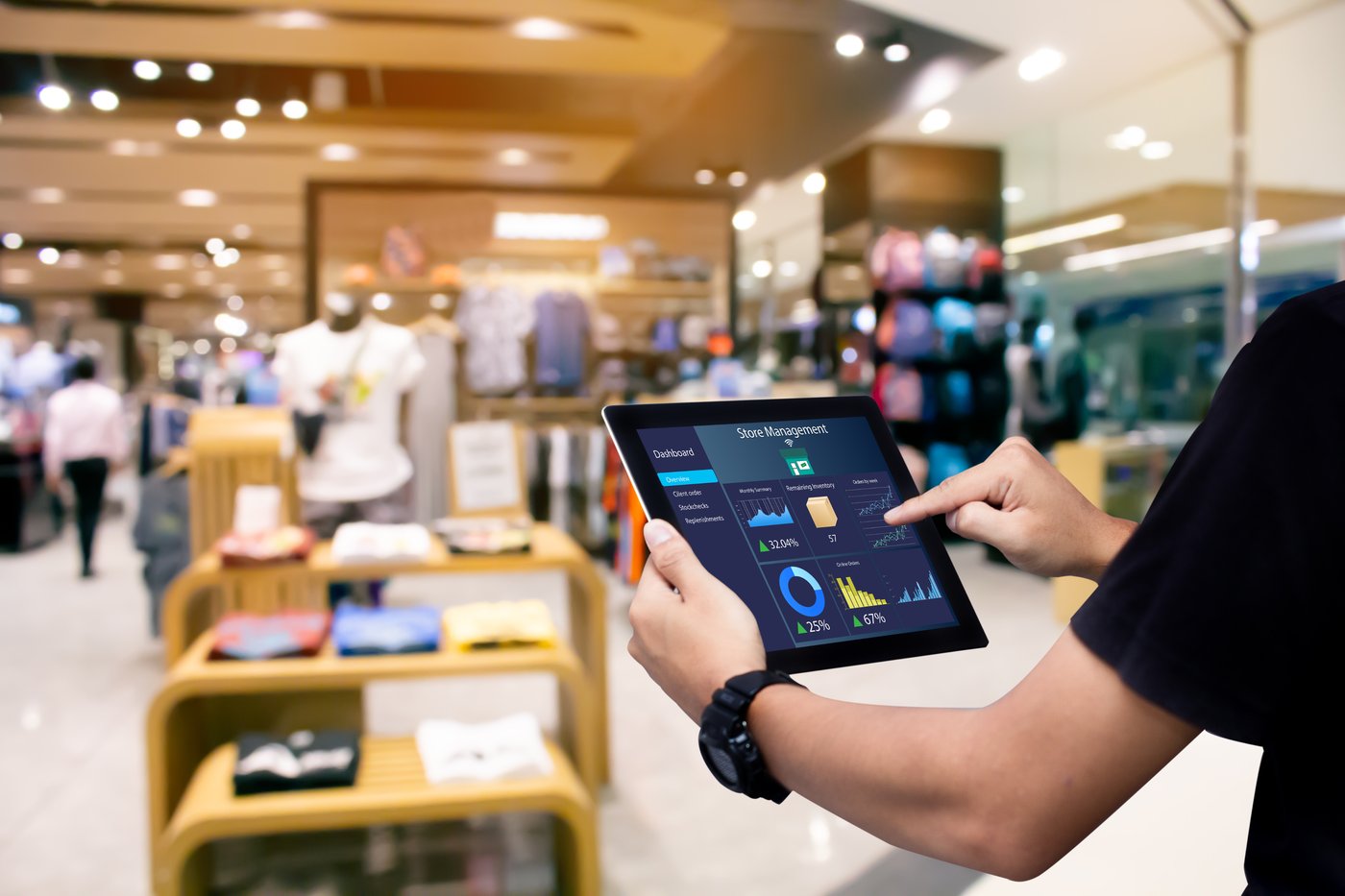 A retail associate reviewing a store management dashboard on a tablet