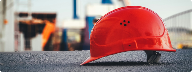 A hard hat resting on a construction site railing
